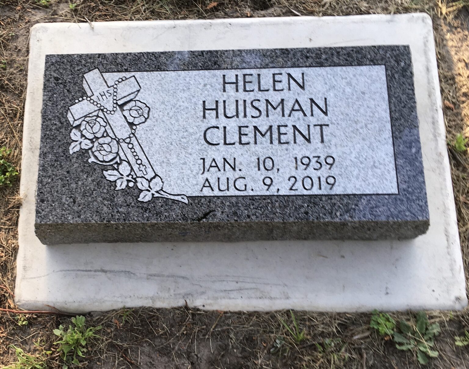 Granite grave marker placed on top of a concrete foundation